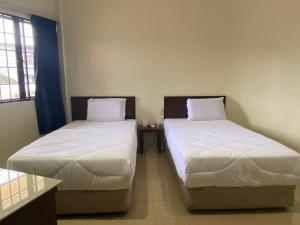 two beds in a room with two beds sidx sidx sidx sidx at Gold Hill Hotel Jerantut in Jerantut