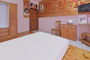 a bedroom with a bed and a desk and a tv at Hotel O Coke Guest House in Masjid Tanah