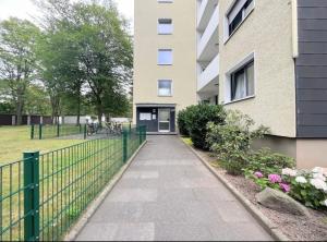 a sidewalk in front of a building with a fence at Wohlfühl-Apartment in Monheim in Monheim