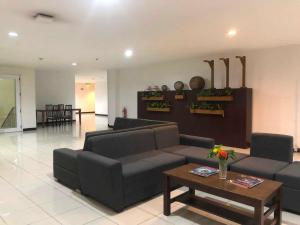 a living room with a couch and a coffee table at Camarin Prime Hotel in Manila +1 photo