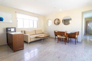 una sala de estar con un sofá y una mesa en Inti Cozy Suite, en Oranjestad