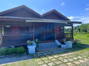 a wooden house with a porch at Hotel O Sri Ayu Inn in Kampung Gurun