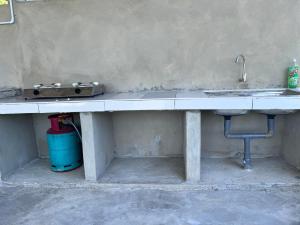 a kitchen counter with a sink and a sink at Hotel O Sri Ayu Inn in Kampung Gurun