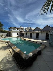 ein Swimmingpool vor einem Haus in der Unterkunft Chalé Casa da Barra in Barra de São Miguel