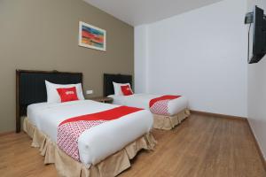 a room with two beds with red and white sheets at OYO 89915 East Mount Hotel in Kukup +38 photos