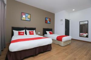 two beds in a hotel room with red pillows at OYO 89915 East Mount Hotel in Kukup