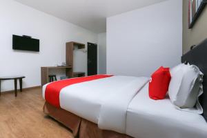 a bedroom with a large bed with red and white pillows at OYO 89915 East Mount Hotel in Kukup