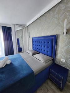 a blue bed with a blue headboard in a room at Grand Bahia Relaxury in Costinesti