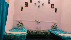 a room with two beds and pictures on the wall at Vardaan Rooms in Prayagraj