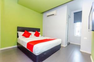 a bedroom with a large bed with red pillows at Hotel O Rooms Boutique Hotel in Johor Bahru