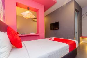 a bedroom with a pink and white bed and a tv at Hotel O Rooms Boutique Hotel in Johor Bahru