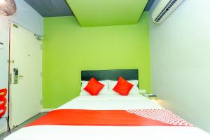 a green room with a bed with red pillows at Hotel O Rooms Boutique Hotel in Johor Bahru +59 photos