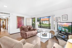 a living room with a couch and a tv at Mountain View Villas Hideaway in Rancho Mirage