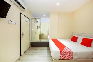 a bedroom with a large bed with red pillows at OYO 479 The Green Hotel in Ampang