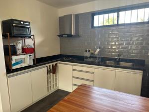a kitchen with a sink and a microwave at Casita Libano in Colonia del Sacramento