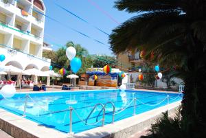 uma piscina num hotel com balões e um parque de diversões em Hotel Parco Dei Principi em Scalea