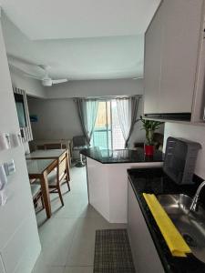 a kitchen with a table and a dining room at Vista Mar 111 in Praia Grande
