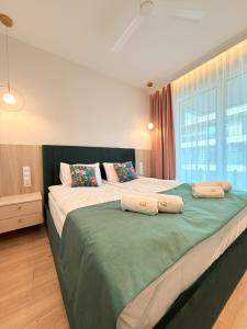 a bedroom with two beds and a large window at Apartament Uzdrowiskowy HYGGE GJ I in Busko-Zdrój