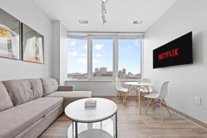 a living room with a couch and a table at Luxe Condo in Downtown Cleveland l 2 TV's l Parking in Cleveland +9 photos