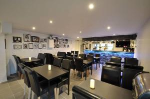 a restaurant with black tables and chairs and a bar at Fishermans House Apartment 2 in Hirtshals