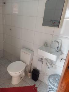 a bathroom with a toilet and a sink at Casa na praia in Caraguatatuba