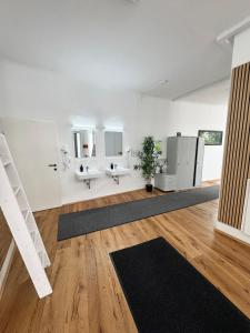 a white room with two sinks and two mirrors at Robin Wood Capsule Hostel in Vienna +6 photos