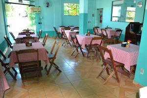 a restaurant with tables and chairs with red and white tablecloths at Hotel Chalé Ji-Parana in Ji-Paraná