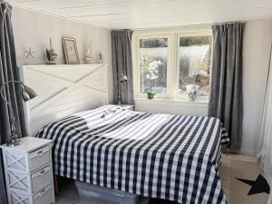a bedroom with a bed with a black and white checkered blanket at 5 star holiday home in MARSTRAND in Marstrand