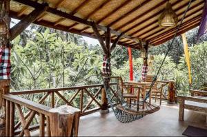 a porch with a hammock and a table and chairs at The Asri Villas in Jembrana