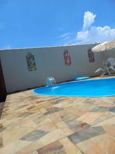 a swimming pool with a table and a chair on a floor at Casa na praia in Caraguatatuba