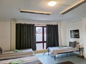 een kamer met twee bedden en een raam bij Gästezimmer 2 in Mönchengladbach