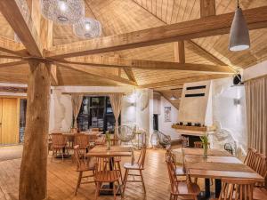a dining room with wooden tables and chairs at Camping Ursulet Durau in Ceahlău +37 photos