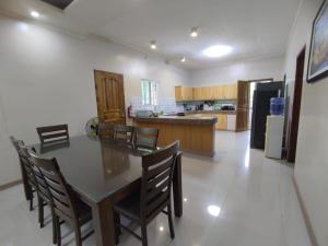 a kitchen with a table and chairs in a room at Hideaway Camiguin Homestay in Mambajao +5 photos
