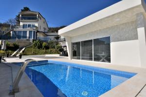 una villa con piscina frente a una casa en Apartments Lux with pool, en Matulji