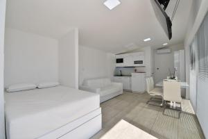 Un dormitorio blanco con una cama blanca y un escritorio. en Apartments Lux with pool, en Matulji