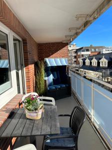 a patio table and chairs on a balcony with a view at Mittendrin 102 in Sylt