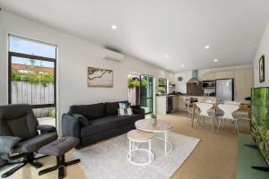 un soggiorno con un divano e un tavolo di Sunny Seaside Retreat - Papamoa Beach a Papamoa