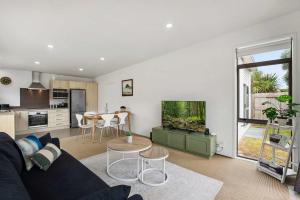 un soggiorno con un divano e un acquario di Sunny Seaside Retreat - Papamoa Beach a Papamoa