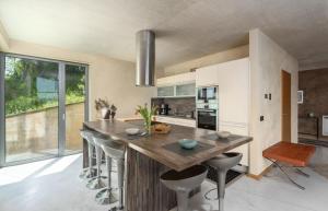 a kitchen with a large wooden island with bar stools at Villa Le Grand Cru in Motovun +24 photos