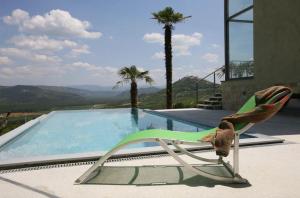 a chair sitting next to a swimming pool at Villa Le Grand Cru in Motovun