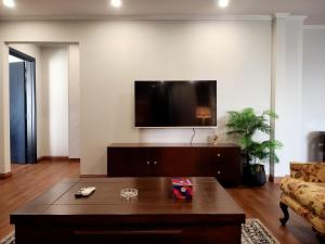 a living room with a coffee table and a flat screen tv at Lahore Luxury Retreats in Lahore