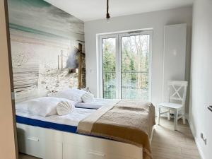 ジブヌフにあるApartament OCEAN & RIVER Sand Dunes Dziwnów z widokiem na morze i rzękę EPapartamentyの大きなベッドと窓のある寝室