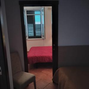 a bedroom with a red bed and a mirror at Le Camere del Corso in Margherita di Savoia