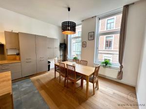 a kitchen and dining room with a table and chairs at Le Botanique des Augustins -100m2 en plein centre in Liège +31 photos