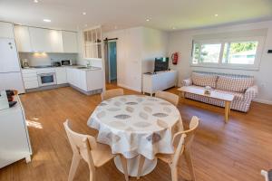 a kitchen and a living room with a table and chairs at Finca Tolombreo Casa Chuchi in Cudillero