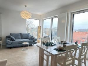 ジブヌフにあるApartament OCEAN & RIVER Sand Dunes Dziwnów z widokiem na morze i rzękę EPapartamentyのテーブルとソファのあるリビングルーム