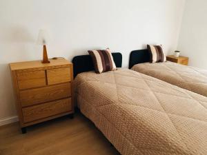- une chambre avec deux lits et une commode avec une lampe dans l'établissement Apartamento Completo T2 - Grândola Vila Morena, à Grândola