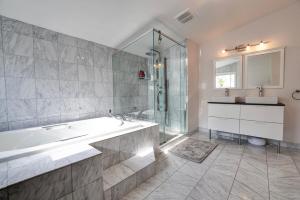a bathroom with a tub and a shower and a sink at Joyful Mansion with Charm Indoor in Mississauga +54 photos