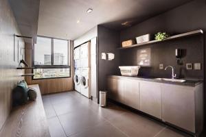 un bagno con lavandino e lavatrice di GO Carlos Gomes by My Way a Porto Alegre