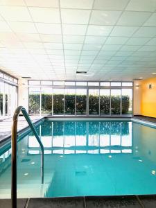 a large swimming pool in a building at Le Fitness & Business Studio - Airbus -Piscine Spa in Toulouse